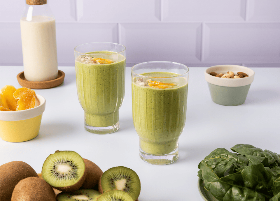 Smoothies verts détox au blender avec kiwi épinards lait végétal dans verres