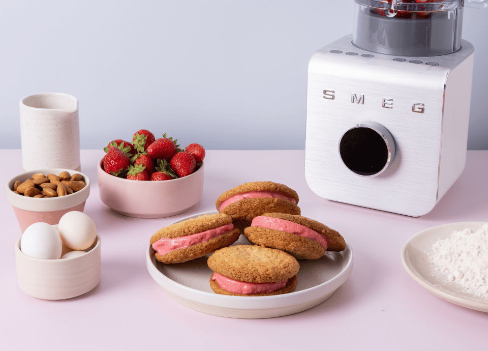 Blender haute performance Smeg blanc pour pâtisserie avec fraises œufs amandes farine et biscuits