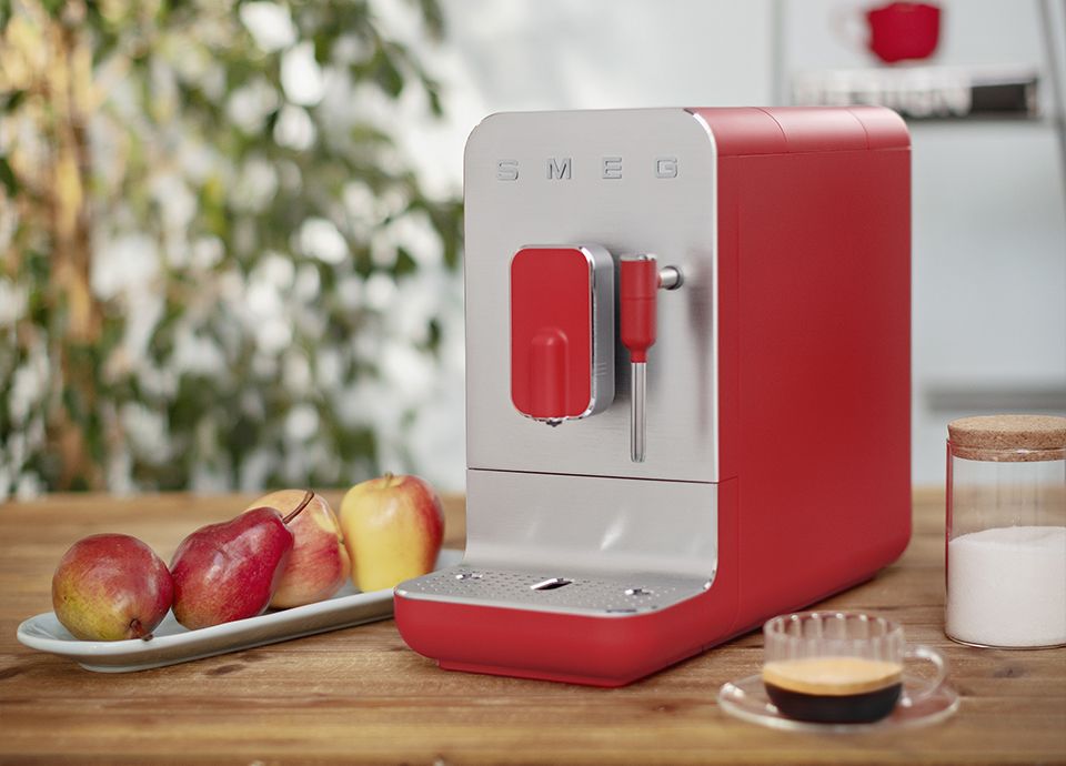 Machine expresso broyeur automatique BCC02RDMEU rouge Smeg sur un plan de travail