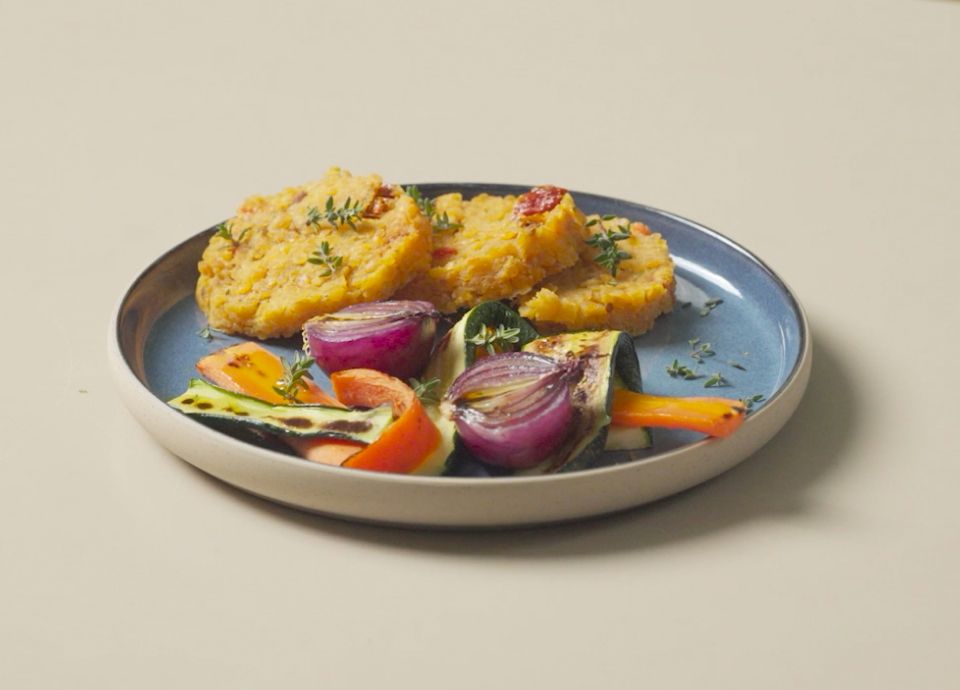 Hamburger di lenticchie serviti con verdure grigliate su un piatto rustico