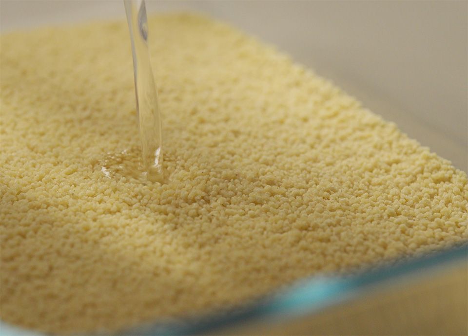 Acqua calda versata nel couscous, pronto per essere cotto