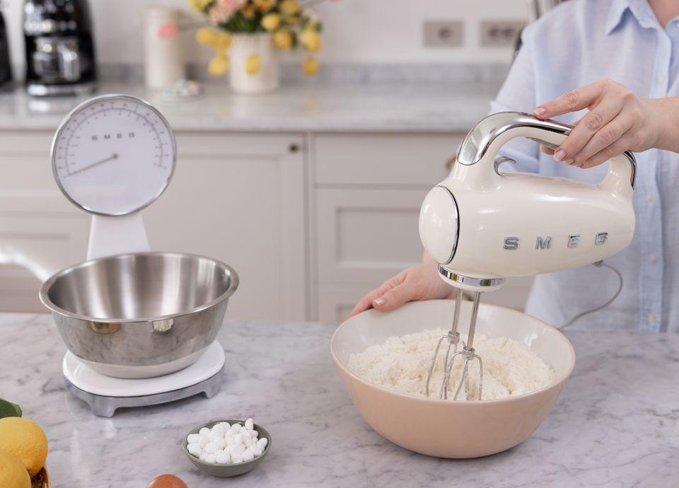 Mélanger la pâte à tarte avec un batteur à main Smeg dans une cuisine